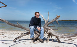 sitting on old tree at the shore